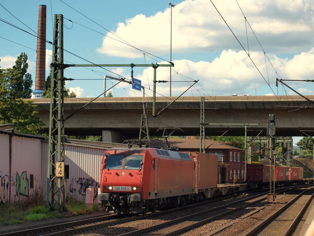 145 050-1 fuhr mit einem Containerzug bei strahlenden Sonnenschein durch Hamburg-Harburg.