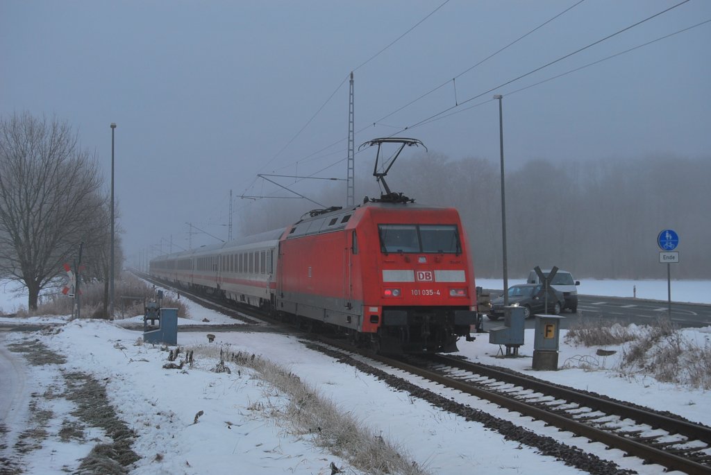 Am kalten und nebeligen 07.12.2010 schiebt 101 035 ihren IC durch Mnchhagen in Richtung Rostock.