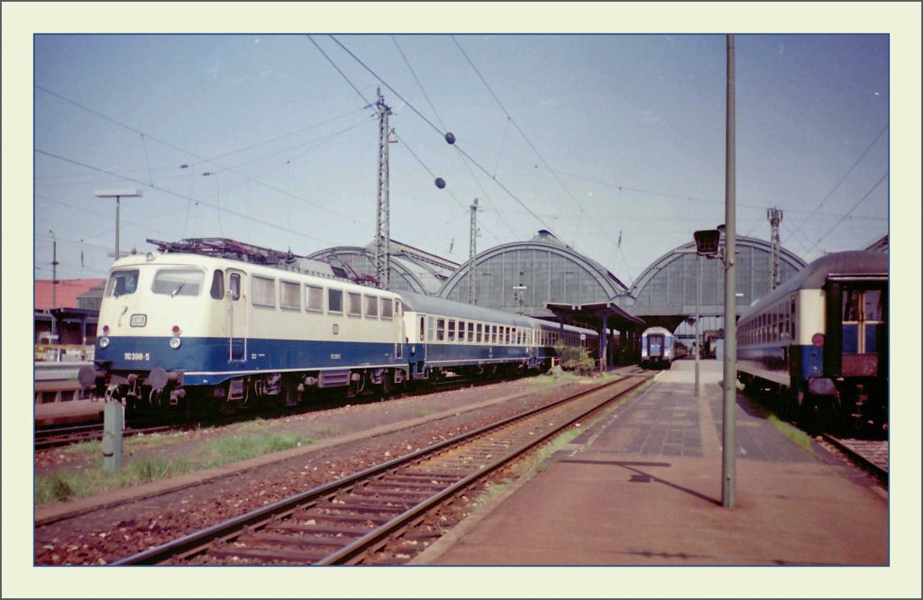 Die DB 110 398-5 mit eine FD vom Ruhrgebiet Richtung Schwarzwald beim Halt in Karlruhe am 18. Mai 1992.