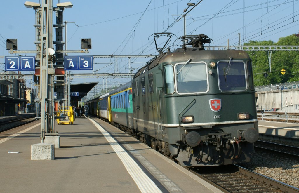 Die grne Re 4/4 II 11309 mit eine RE nach Lausanne beim Halt in Morges. 
1. Mai 2009 