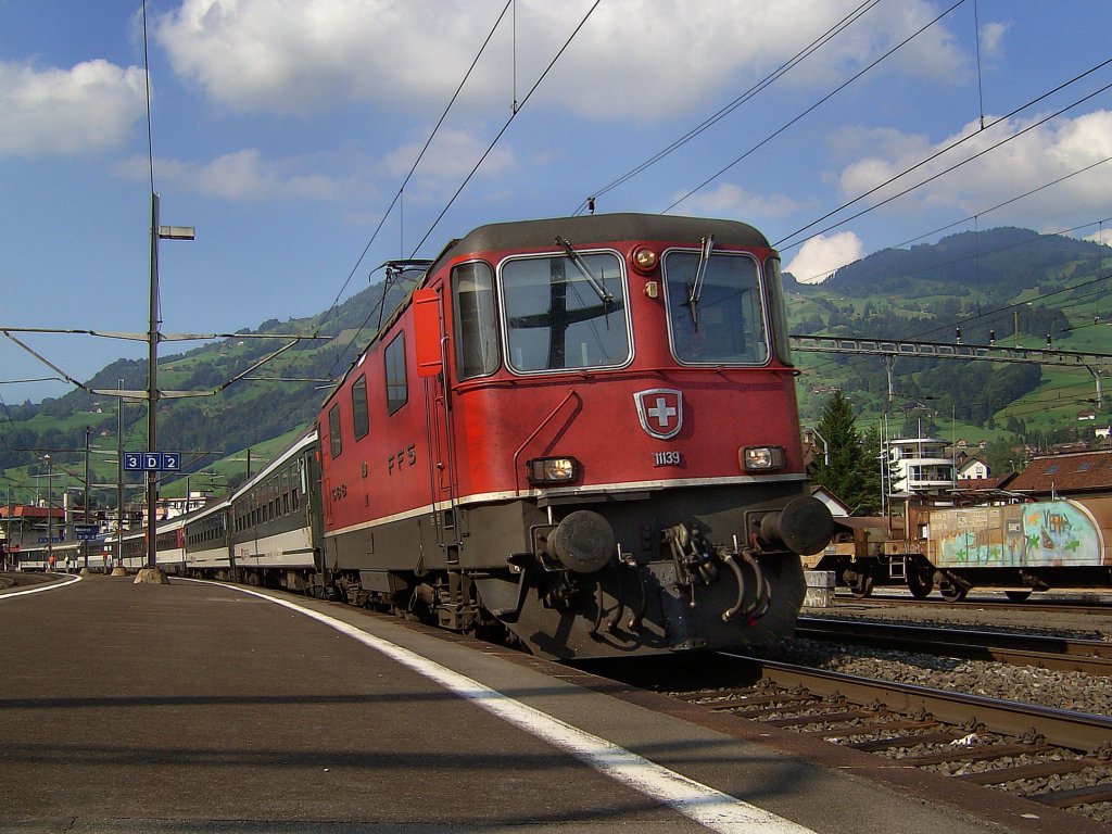 Die Re 4/4 11139 am 27.08.2008 mit einem IR bei der Ausfahrt in Schwyz.