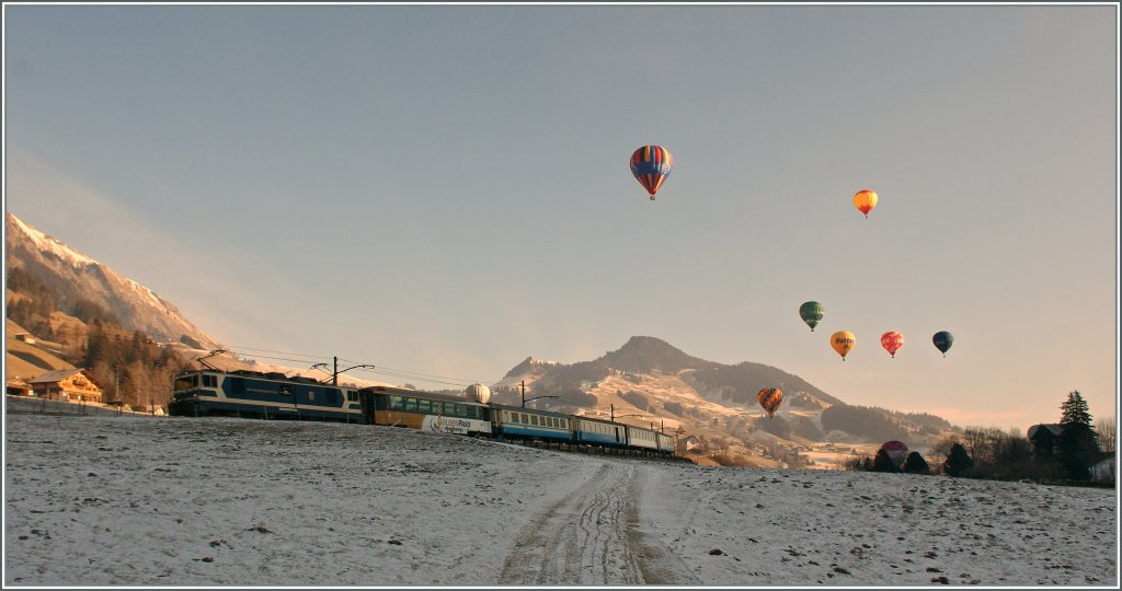 Es war kaum mglich, die Ballone, den Zug und das Licht in Einklang zu bringen: GDe 4/4  Vevey  mit dem Regionalzug 2213 in Chteau d'Oex m 23. Jan.  2011