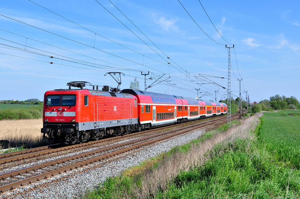 Mit dem RE1 nach Hamburg hat die 112 114 gerade Rostock verlassen.Fr eine ausgefallene 120.2 sind die Loks der BR 112 immer wieder auf der RE-L:inie anzutreffen.Geknipst am 14.05.2012 in Sildemow.