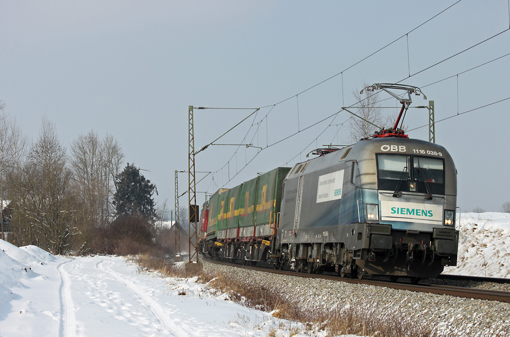 BB-Taurus 1116 038 mit Siemens-Werbung zieht einen Gterzug in Richtung Rosenheim. Abgelichtet am 11.2.2012 bei Ostermnchen.