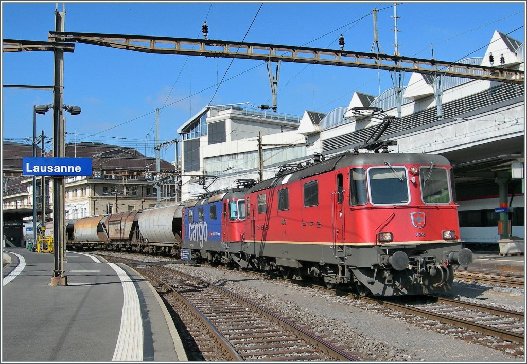 Re 4/4 II N 11348 und eine Re 420 mit einem langen Getreidezug Richtung Italien bei der Durchfahrt in Lausanne am 7. Oktober 2010.