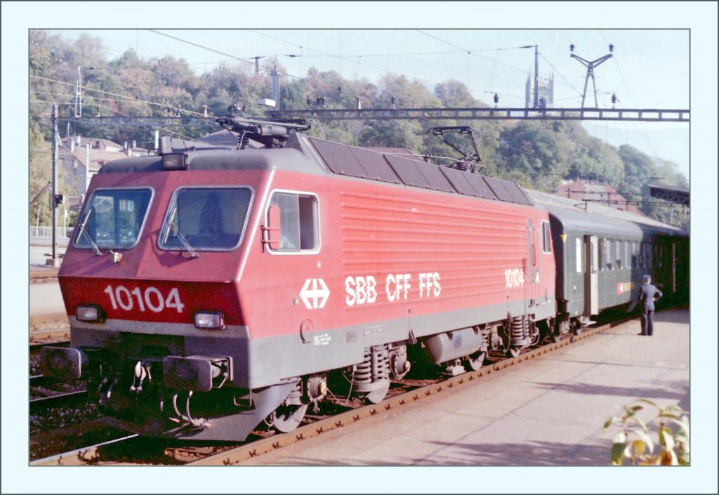 SBB Re 4/4 IV 10104 mit einem Schnellzug nach Lausanne in Vevey im Sommer 1985. (Gescanntes Negativ)