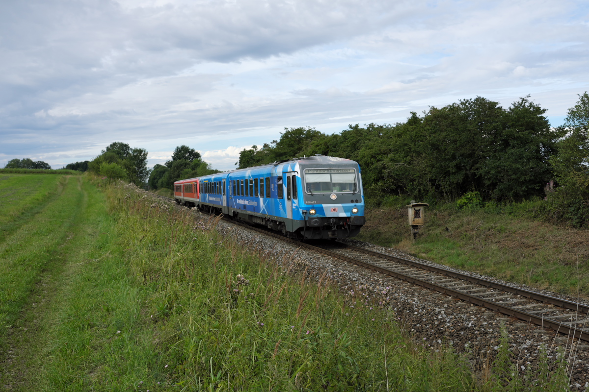 Der für  Bahnland Bayern  werbende 628 423-6 konnte zusammen mit 628 618-1 bei Unterschwillach auf seiner sonntäglichen Fahrt am Vormittag von München Hbf nach Mühldorf im Bilde festgehalten werden. (30.07.17)