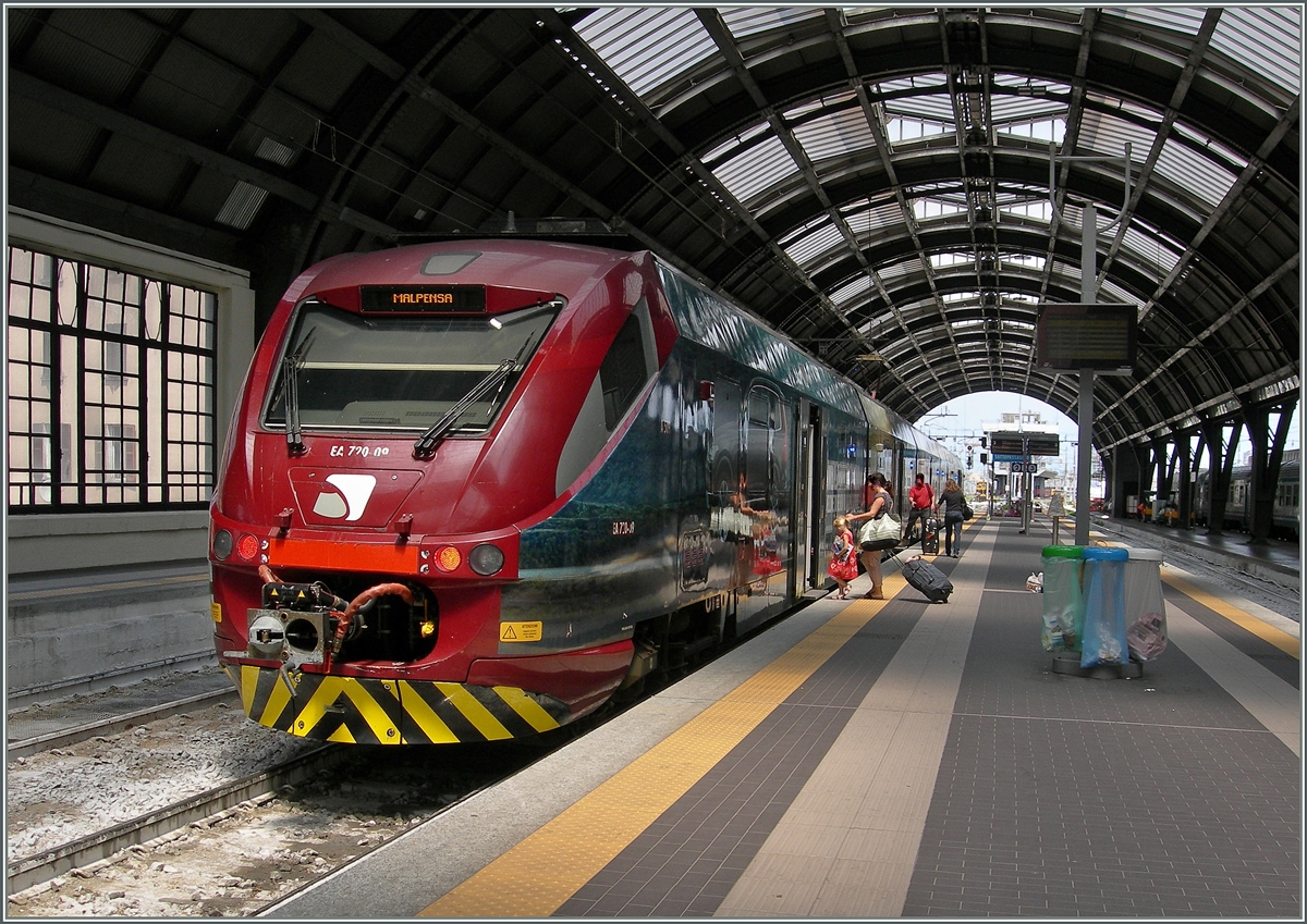 Der  Malpensa Express ist praktisch rundum mit Werbung beklebt.
(Den Triebzug kannte ich als ETR 245, nun ist er mit EA 720 und auf der anderen Seite mit EA 721 angeschrieben, sobald ich näher weiss melde ich mich zu diesem Thema.)
Milano, den 22. Juni 2015