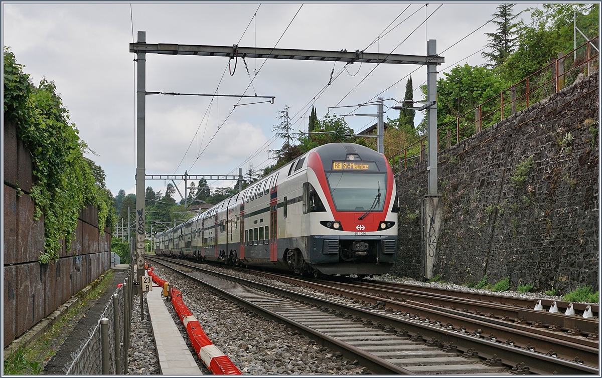 Der SBB RABe 511 020 ist zwischen Lärmschutzwänden und Stützmauern bei Montreux auf dem Weg nach St-Maurice. 

6. Mai 2020