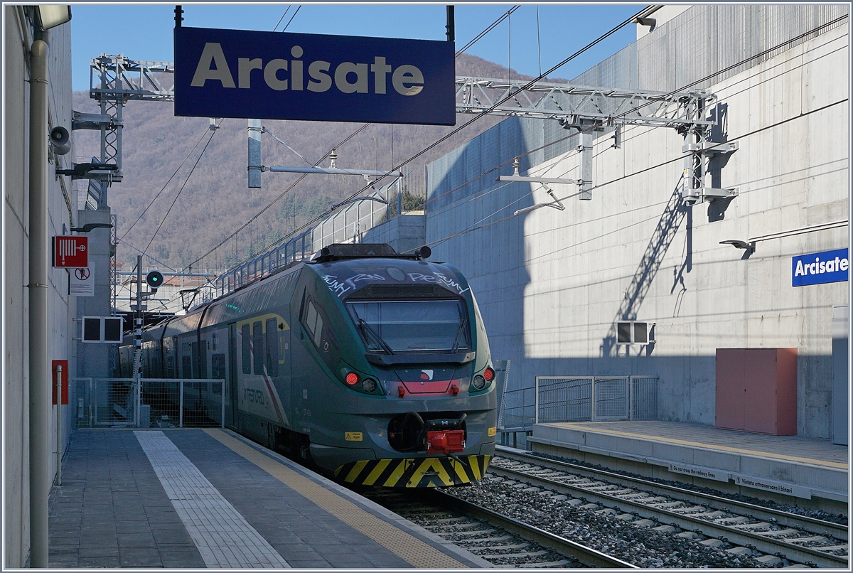 Der Trenord ETR 425 030 als RE nach Milano Porta Garibaldi verlässt den Bahnhof Arcisate.
Bei der kompletten Sanierung für als Zufahrt zur Neubaulinie Bevera (km 7.525) - Stabio wurde die Bestandlinie in den bewohnten Gebieten tiefer gelegt und mit zweckmässigen, aber wenig fotogenen Bahnhöfen ausgestattet.
5. Jan. 2019