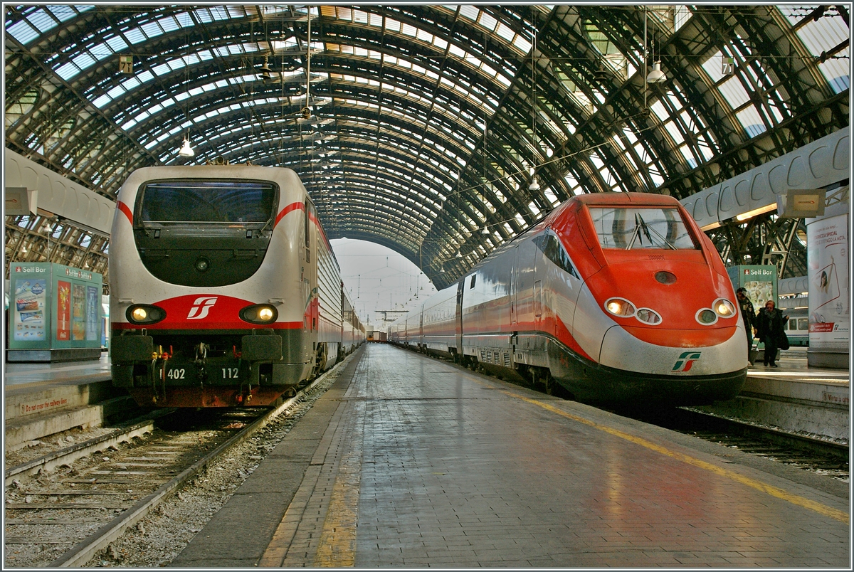 Die Trenitalia E 402 112 in Frecce-Bianca Farbgebung und ein ETR 500 als Frecce Rossa  in Milano Centrale. 
16. Nov. 2013