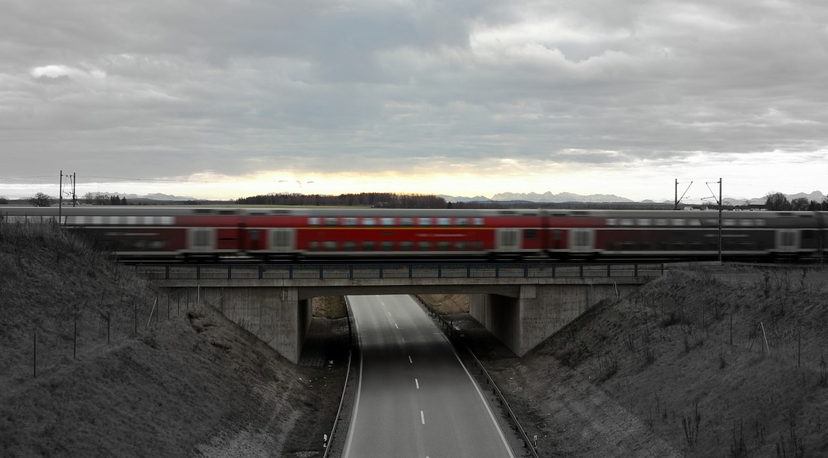 Ein Doppelstockzug von Mühldorf nach München überquerte am 23.12.13 eine Straßenbrücke am Rande Markt Schwabens. Im Hintergrund sind die Alpen zu erkennen.