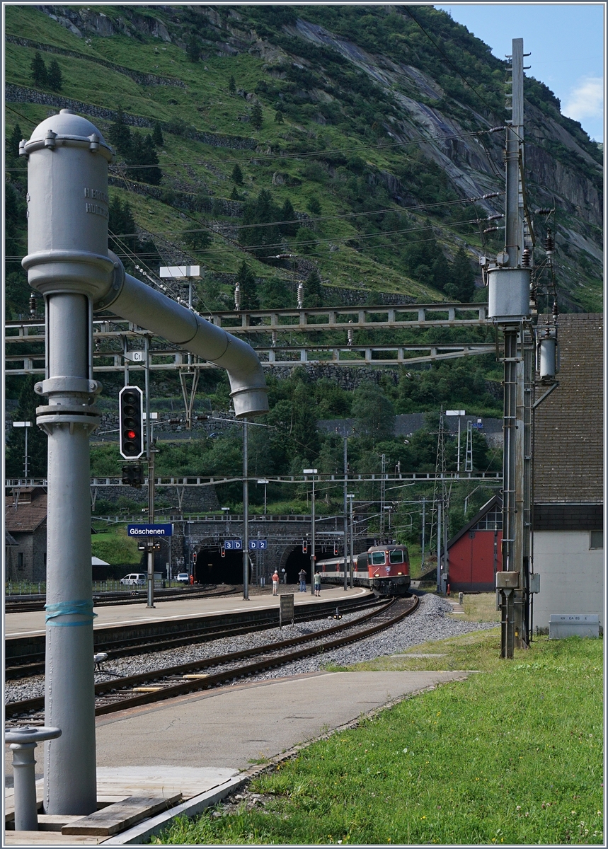 Eine Re 4/4 II verlässt mit ihrem IR den Gotthard Tunnel und erreicht Göschenen. 
Der Wassertrum im Vordergrund wird in gut einer Stunde für die durstige C 5/6 2978 gebraucht.
28. Juli 2016