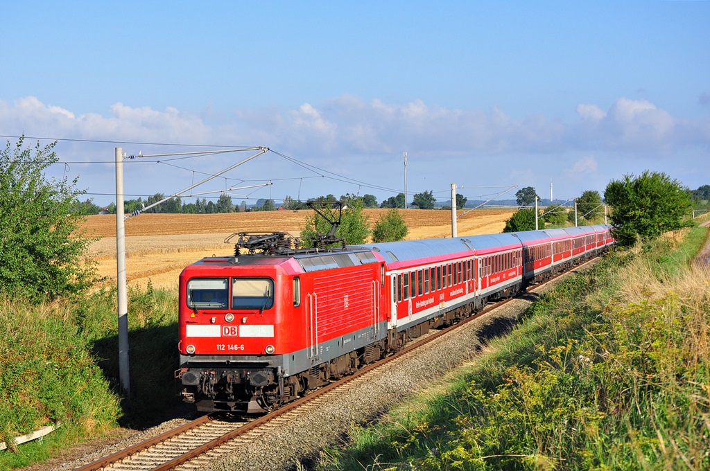 Ihren 12-Wagen starken Kreuzfahrerzug zieht die 112 146 am 31.07.2014 nach Berlin.Hier kurz vor Kavelstorf.Im Zug befanden sich Passagiere der in Warnemünde liegenden  Royal Princess .