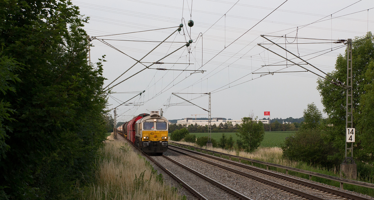 Mit Blick auf das  OCE - a Canon Company  in Poing wurde 247 043-3 mit ihrem gemischten Güterzug nach München Nord Rbf vom Bahnsteigende in Grub (Oberbay) am Abend des 22.06.17 fotografiert.