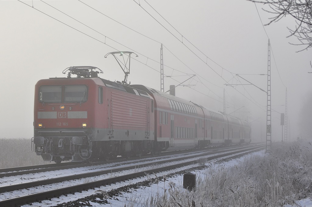 Mit dem RE 4352 (Lutherstadt Wittenberg-Rostock Hbf)rollt die Berliner 112 165 am vernebelten 06.02.2015 durch Sildemow ihrem letzten Halt Rostock entgegen.