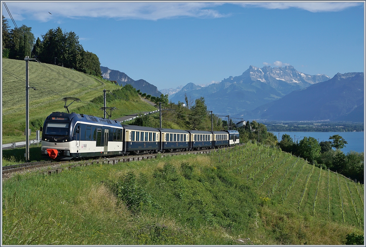 Vor der Kulisse des (fast) Wolken freien Dents de Midi im Hintergrund fährt ein MOB Belle Epoque Zug von Montreux nach Zweisimmen und erreicht in kürze den Haltestelle Planchamp.

8. Juli 2020