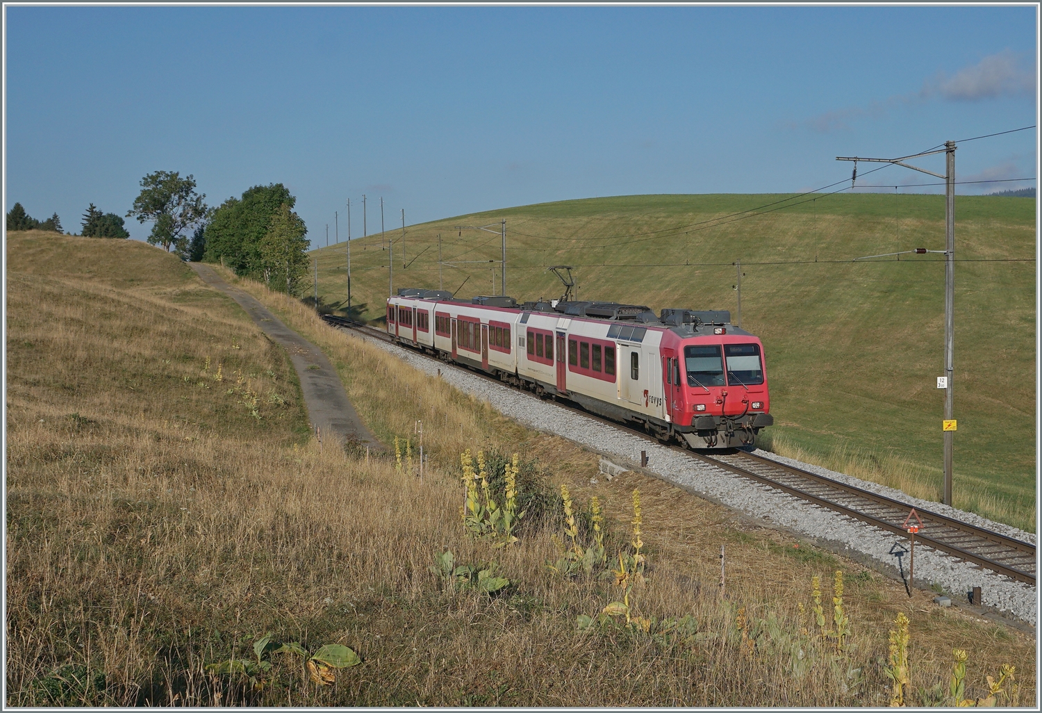 Der Travys RBDe 560 384-0 (RBDe 560 DO TR 94 85 7 560 384- CH-TVYS)  Lac Brenet  mit B und ABt ist als Regionalzug von Le Brassus nach Vallorbe kurz vor Les Charbonnières unterwegs. 

21. Juli 2022