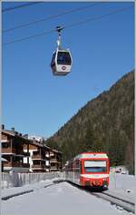 alpen-metro-martigny---vallorcine---chamonix---st-gervais/815134/der-tmr-beh-48-71-erreicht Der TMR Beh 4/8 71 erreicht sein Ziel Vallorcine, während hin der Höhe eine Gondle der Seilbahn vorüber schwebt. 

14. Februar 2023