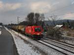 Die 1116 028 am 27.11.2010 mit einem Silowagenzug unterwegs bei Vilshofen.