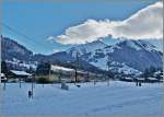Zwei  Lenker -Pendelzüge nach Rougemont bei Gstaad mit der entsprechenden Fotowolke im Hintergrund.