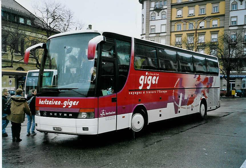 (057'411) - Giger, La Chaux-de-Fonds - NE 61'021 - Setra am 30. November 2002 beim Bahnhof La Chaux-de-Fonds