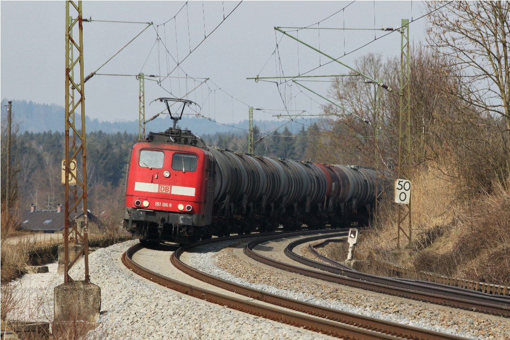 151-136 mit Kesselwagenzug in Kurvenfahrt bei Ostermnchen (Mnchen - Rosenheim) am 12.3.2011.