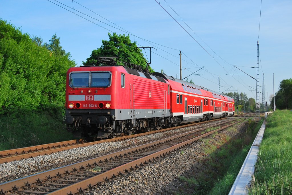 Aus Gstrow kommend rollt die 143 303 am 09.05.2011 durch Sildemow in Richtung Rostock Hbf.