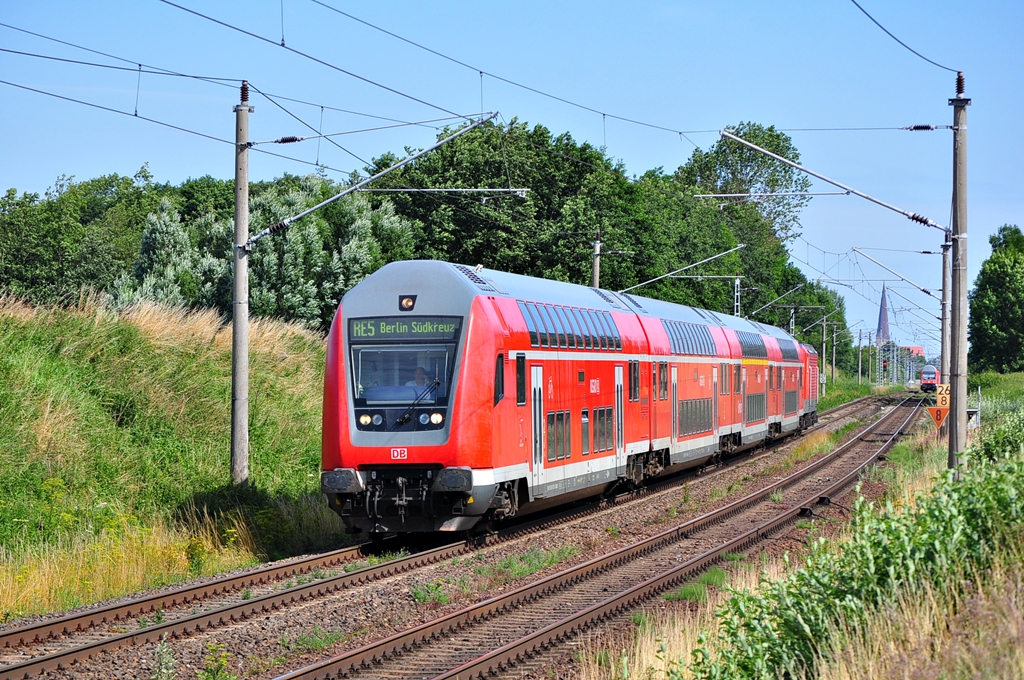 Der RE 5 nach Berlin-Sdkreuz rauscht am 23.07.2012 durch Sildemow.Am Zugschluss schiebt die 112 120.