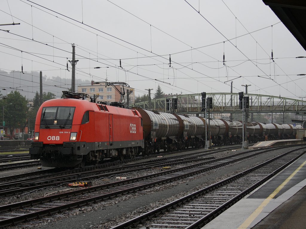 Die 1016 004 mit einem Kesselwagenzug bei Strmenden Regen am 22.08.2009 bei der Ausfahrt aus dem Salzburger Hbf.