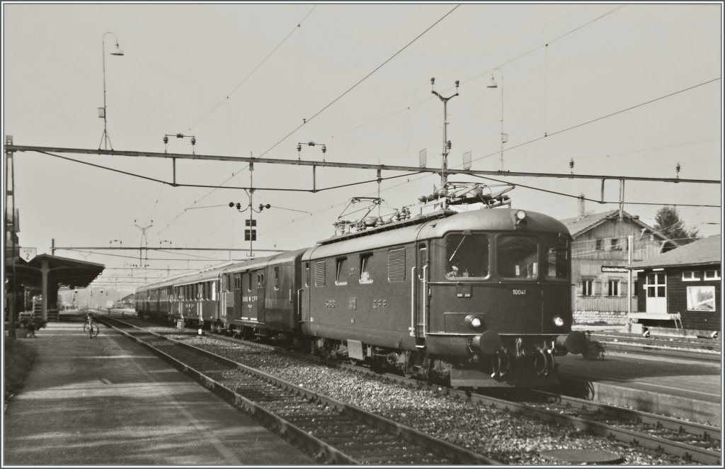 Die Re 4/4 I 10041 mit einem Schnellzug nach Delmont beim Halt in Grenchen Nord. 
Sommer 1984