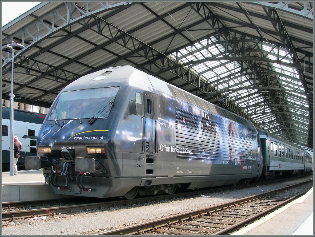 Die SBB Re 460 019-3 mit der neuen  Werbung fr das  Verkehrshaus der Schweiz  mit eine mIR nach Genf beim Halt in Lausanne am 10. Juni 2011.