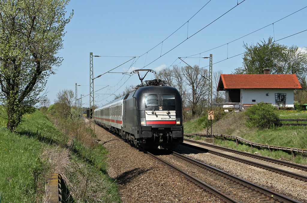 ES 64 U2-074 von MRCE Dispolok mit dem IC Knigssee am Blockhaus Hilperting vorbeifahrend in Richtung Rosenheim (28.4.2012).
