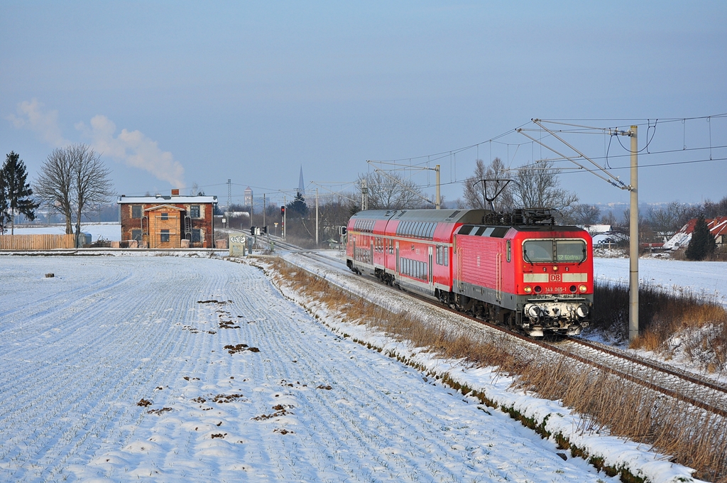 Im einzigen Sonnenloch des Tages saust die 143 065 mit ihrer S-Bahn nach Gstrow.Gragetopshof am 16.01.2013.