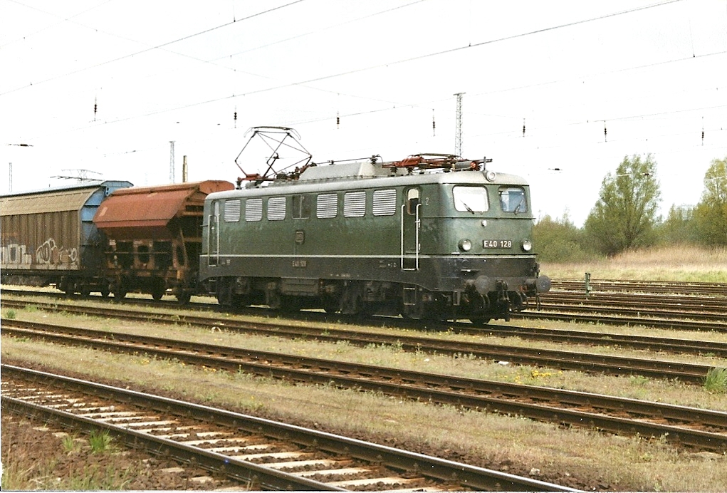 Im Zuge ihrer im Werk Opladen zum 21.05.2001 ausgefhrten HU wurde die 140 128 wieder in Ursprungszustand zurckversetzt.Mit einem Zug nach Mukran zeigt sich die Lok am 30.04.2002 in Rostock-Seehafen.Hinweis:Eingescanntes Bild.
