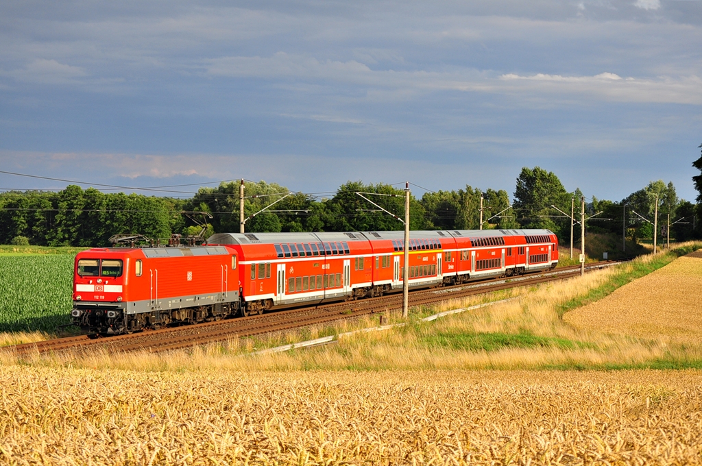 Mit dem RE 5 aus Berlin Sdkreuz rauscht die 112 119 durch das kleine Dorf Benitz ihrem Ziel Rostock entgegen.Geknipst am 16.07.2012.