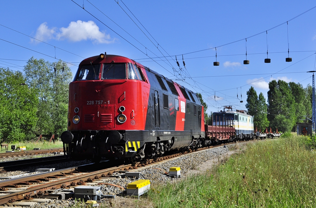 Mit einer ehemaligen E-Lok der KEG im Schlepp,rollt die 228 757 in Bhf Rostock-Seehafen.