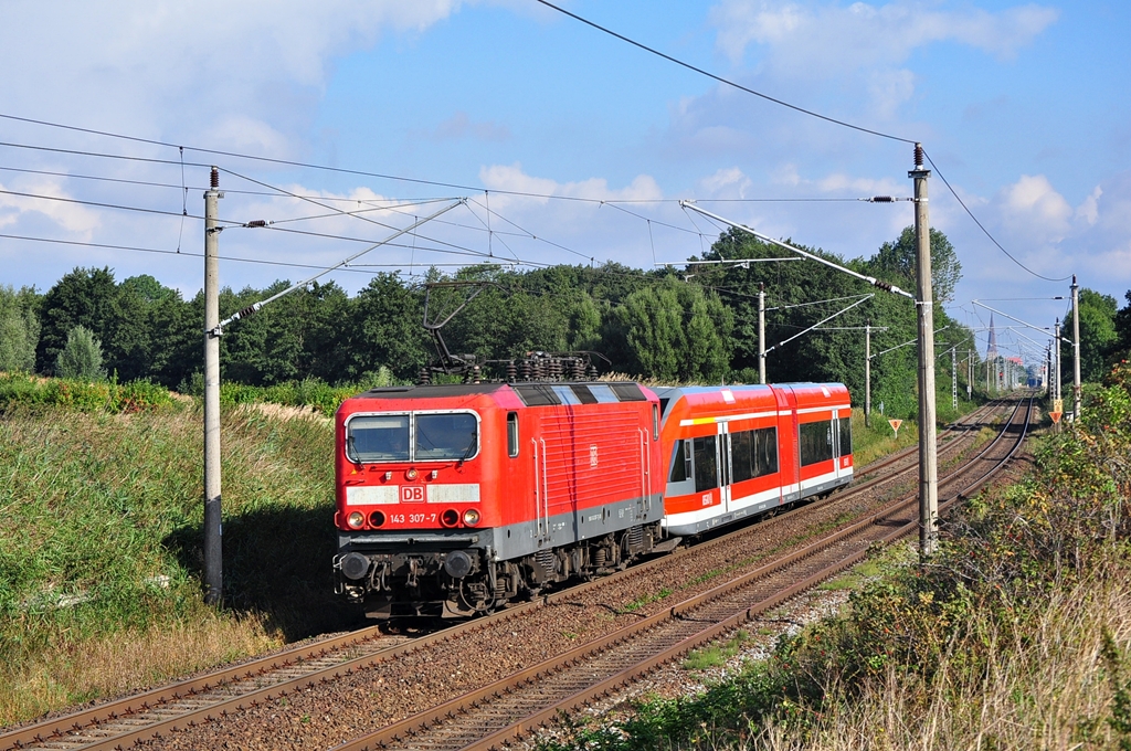 Mit einem Triebwagen der Baureihe 646 im Schlepp rollt die 143 307 durch Sildemow.Geknipst am 13.09.2012.