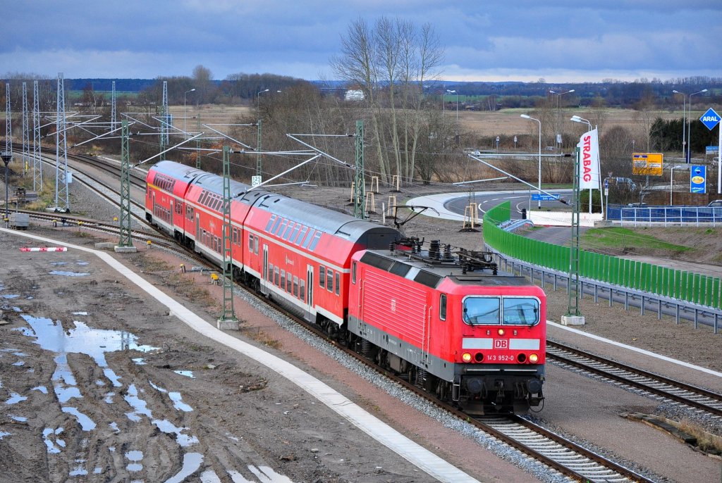 Mit ihrer S-Bahn  aus Rostock Hbf erreicht am 06.01.2012 die 143 952 den nach dem Umbau nicht mehr wiederzuerkennden Hp Warnemnde Werft.