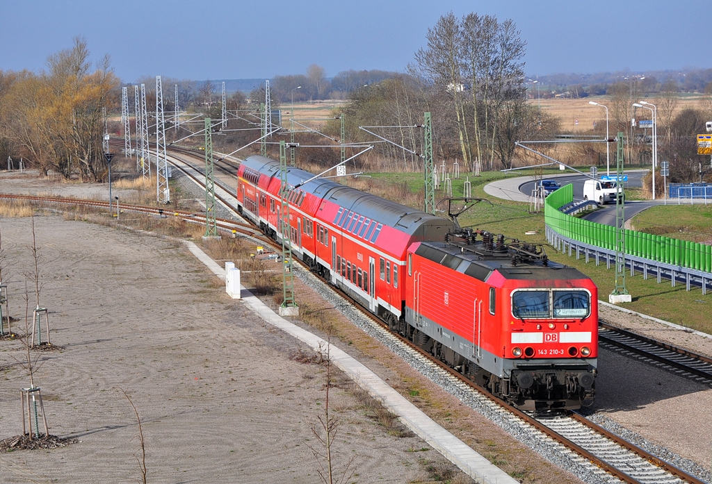 Mit einer S-Bahn nach Warnemnde rollt die 143 210 am 17.04.2013 ihrem vorletzten Halt Warnemnde Werft entgegen.