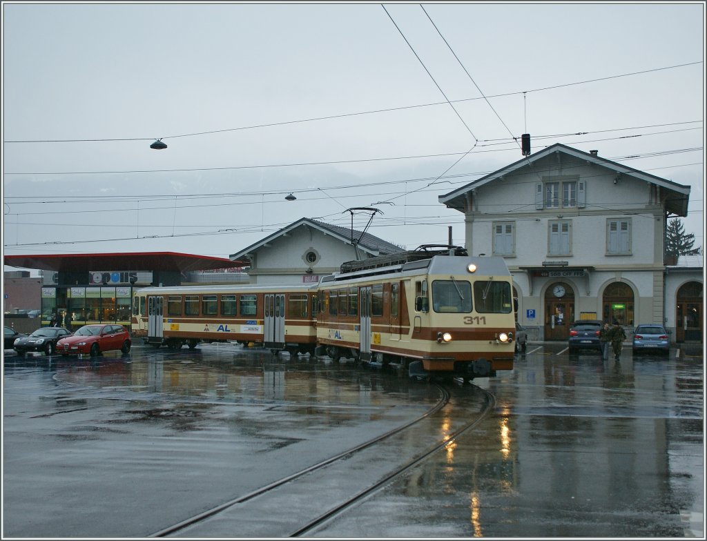 Pflgt sich durch Verkehr und Regen: A-L Regionalzug nach Leysin kurz nach der Abfahrt in Aigle. 
19. Mrz 2011