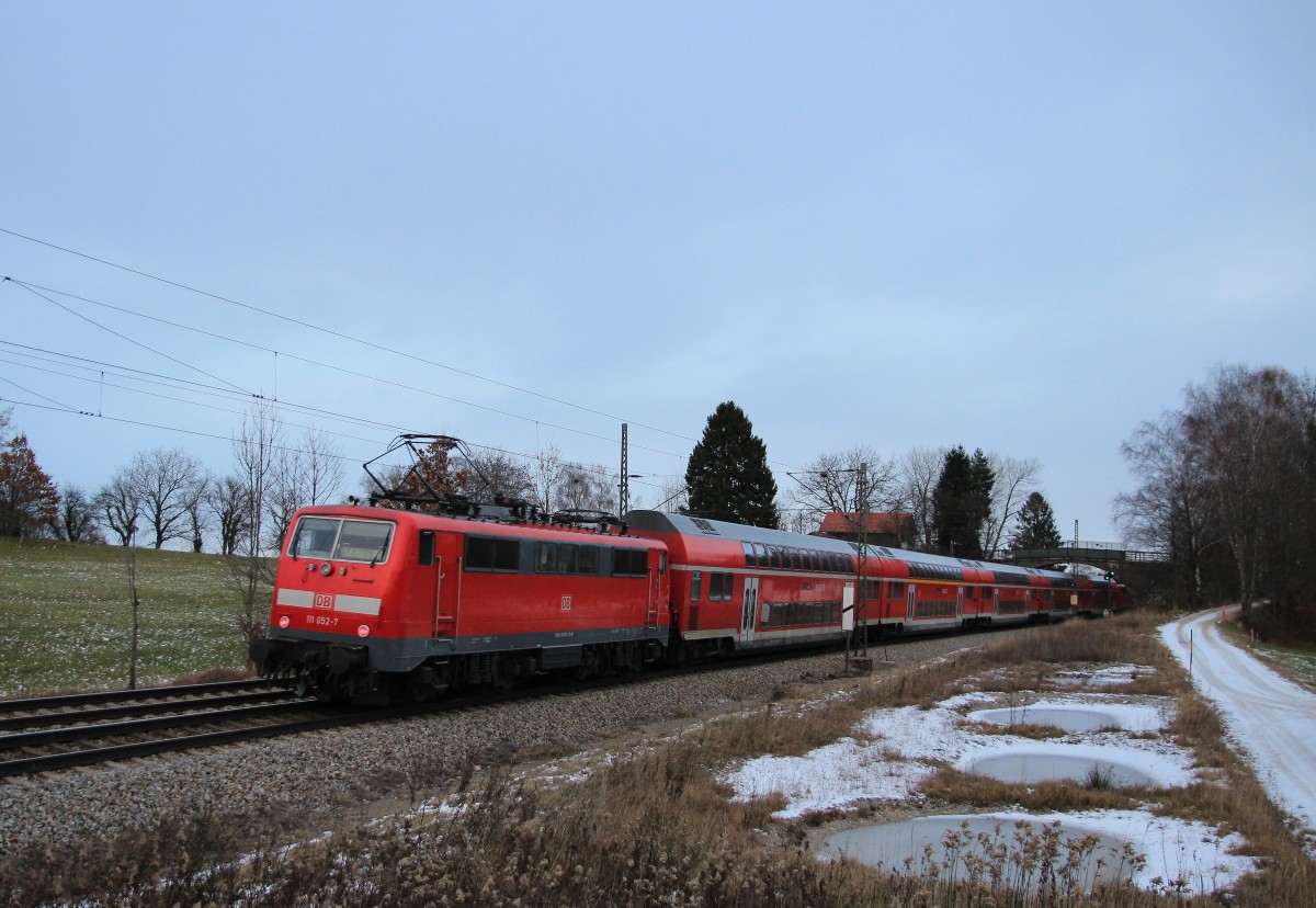 111 052-7 schiebt am 7. Dezember 2013 einen Regionalzug bei Übersee in Richtung Salzburg.