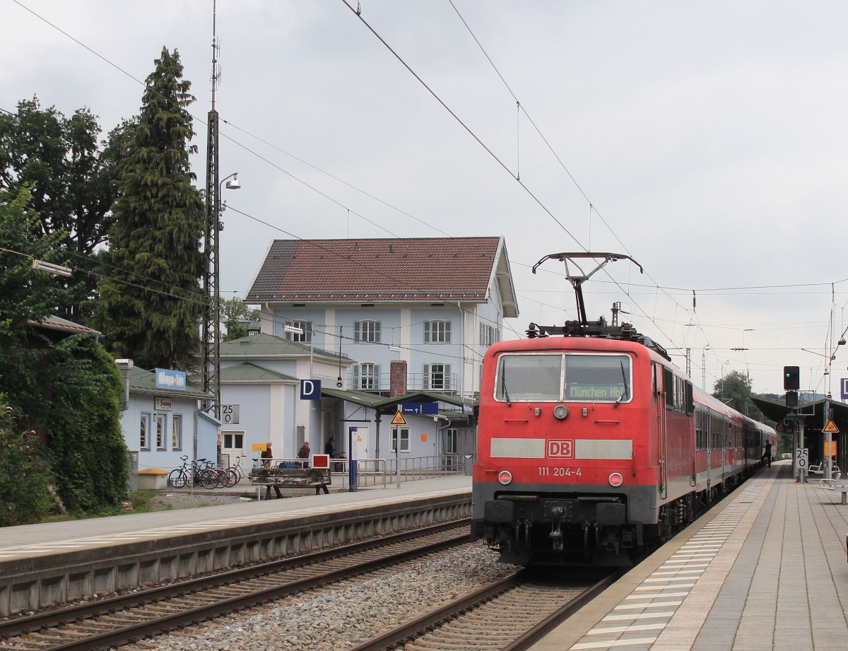 111 204-4 war am 27. August 2013 mit einem Regionalzug von Salzburg nach München unterwegs. Das Bild entstand im Bahnhof von Prien am Chiemsee.