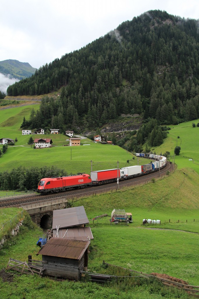 1116 032-2 ist mit einem Containerzug in Richtung Brenner unterwegs. Aufgenommen am 5. August 2014 bei St. Jodok.