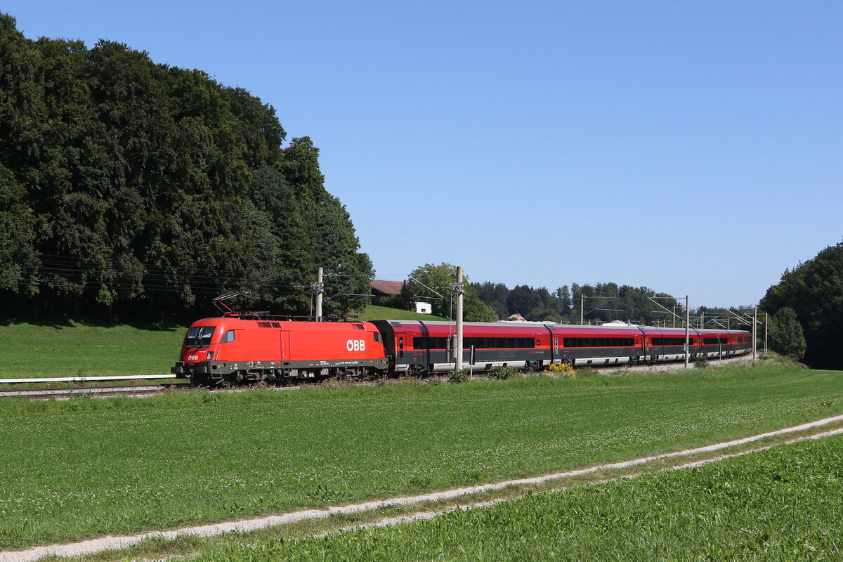 1116 131 schiebt einen  Railjet  am 6. September 2023 bei Traunstein in Richtung Salzburg.