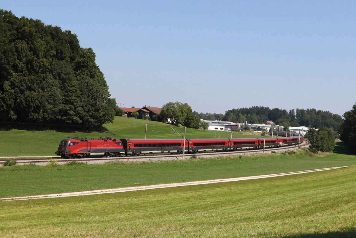 1116 219 aus Salzburg kommend am 22. August 2023 in der  Axdorfer Kurve bei Traunstein.