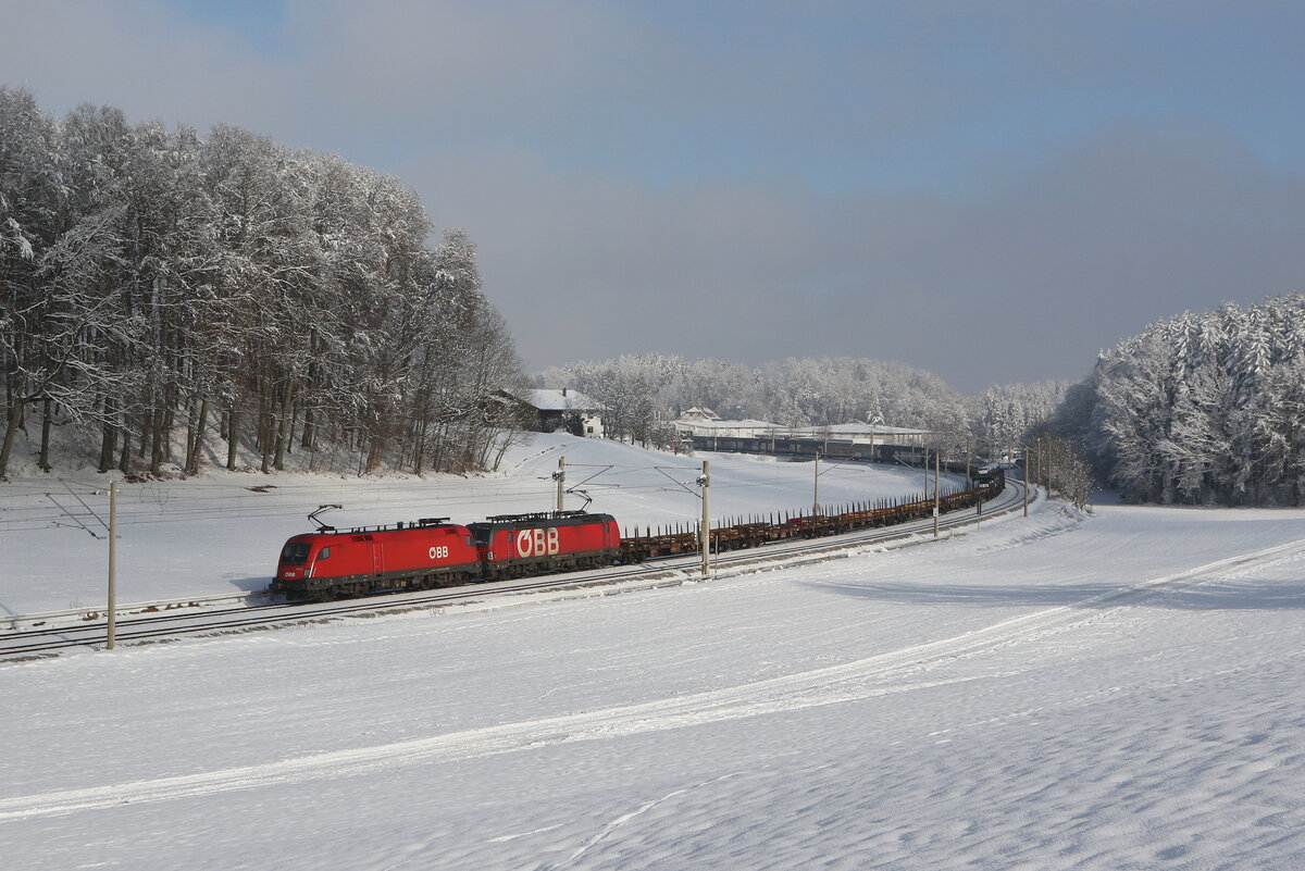 1116 278 und 1293 189 mit einem gemischten Gterzug aus Salzburg kommend am 13. Januar 2024 bei Axdorf im Chiemgau.