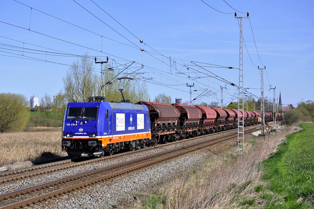 185 419 von RAILDOX rollt mit einem Düngerzug aus Poppendorf am 21.04.2015 durch Dalwitzhof in Richtung Schwerin.