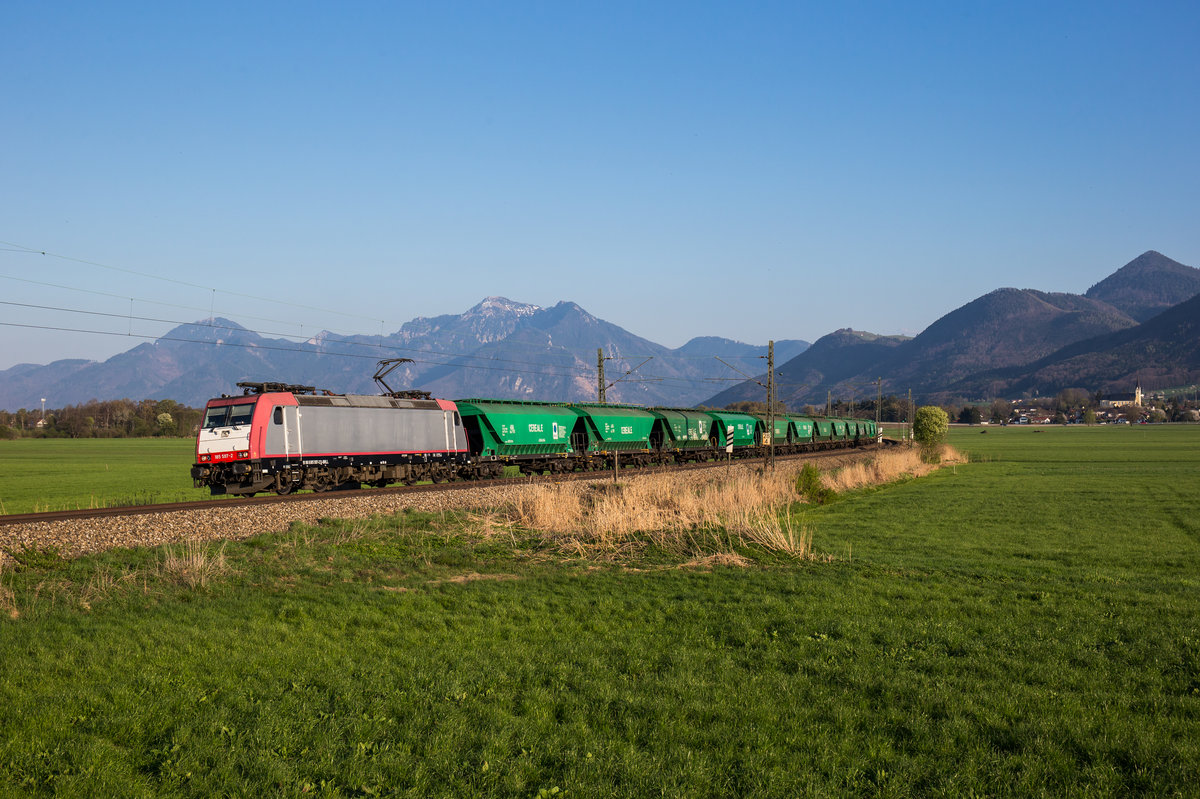 185 597-2 mit einem Getreidezug aus Salzburg kommend am 9. April 2017 bei Bernau am Chiemsee.