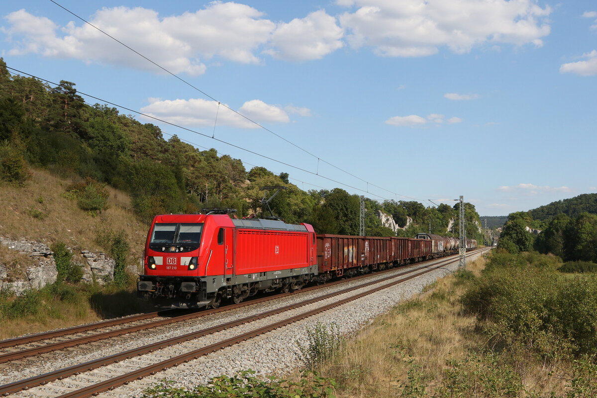 187 210 mit einem gemischten Gterzug am 9. August 2022 bei Hagenacker im Altmhltal.